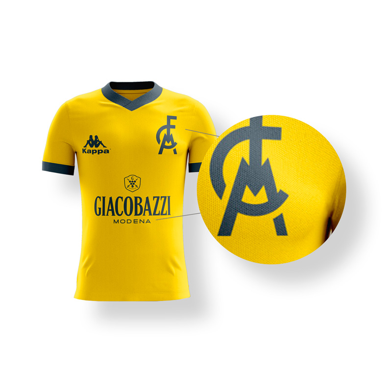 Dettaglio marchi sponsor e logo Modena FC. Il logo dello sponsor e il marchio ufficiale del Club è in contrasto cromatico a tinta unita gialla o blu rispetto al colore principale della maglia.